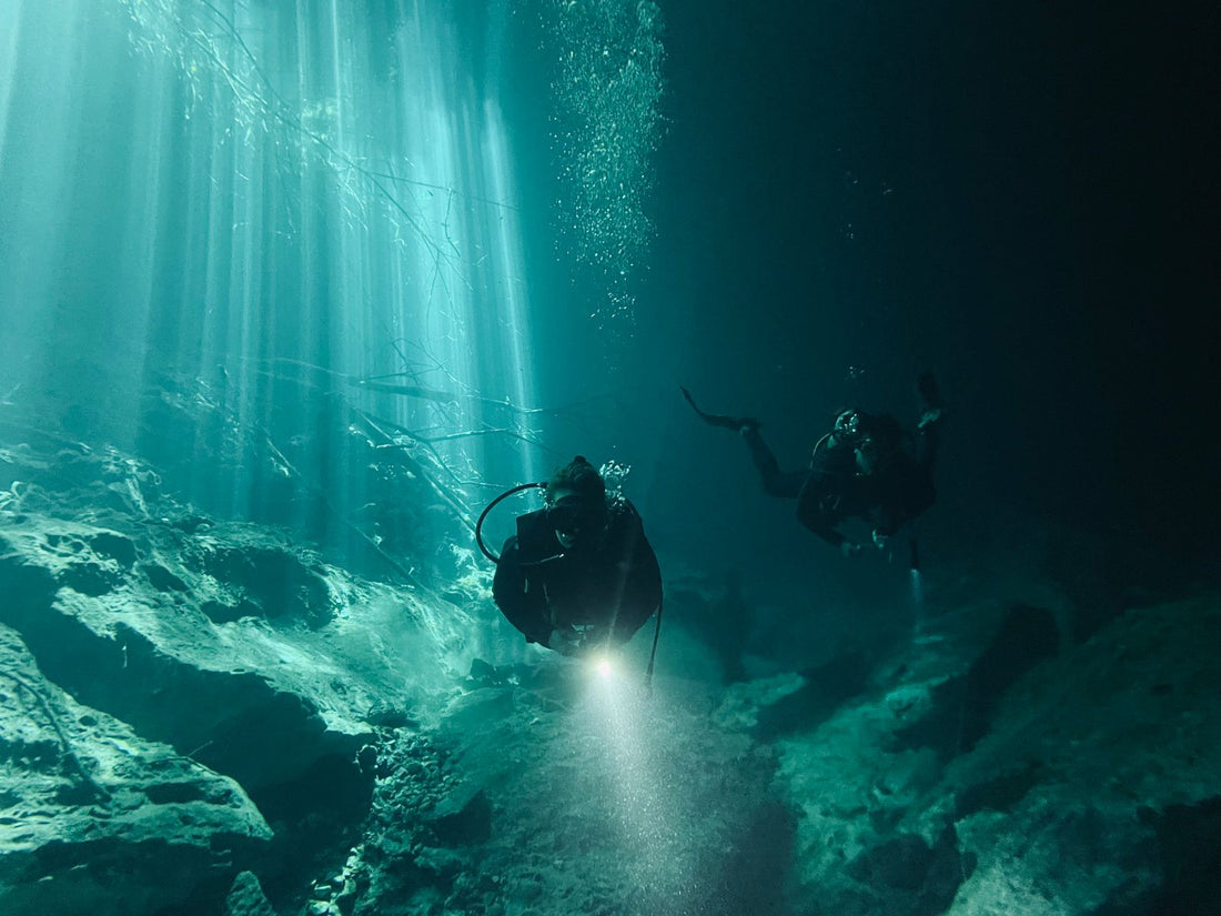 Scuba divers underwater in Bali during rainy season exploring a sheltered reef site