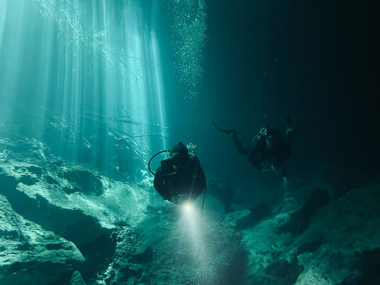 Scuba divers underwater in Bali during rainy season exploring a sheltered reef site